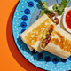 Burrito on colorful blue plate and orange background